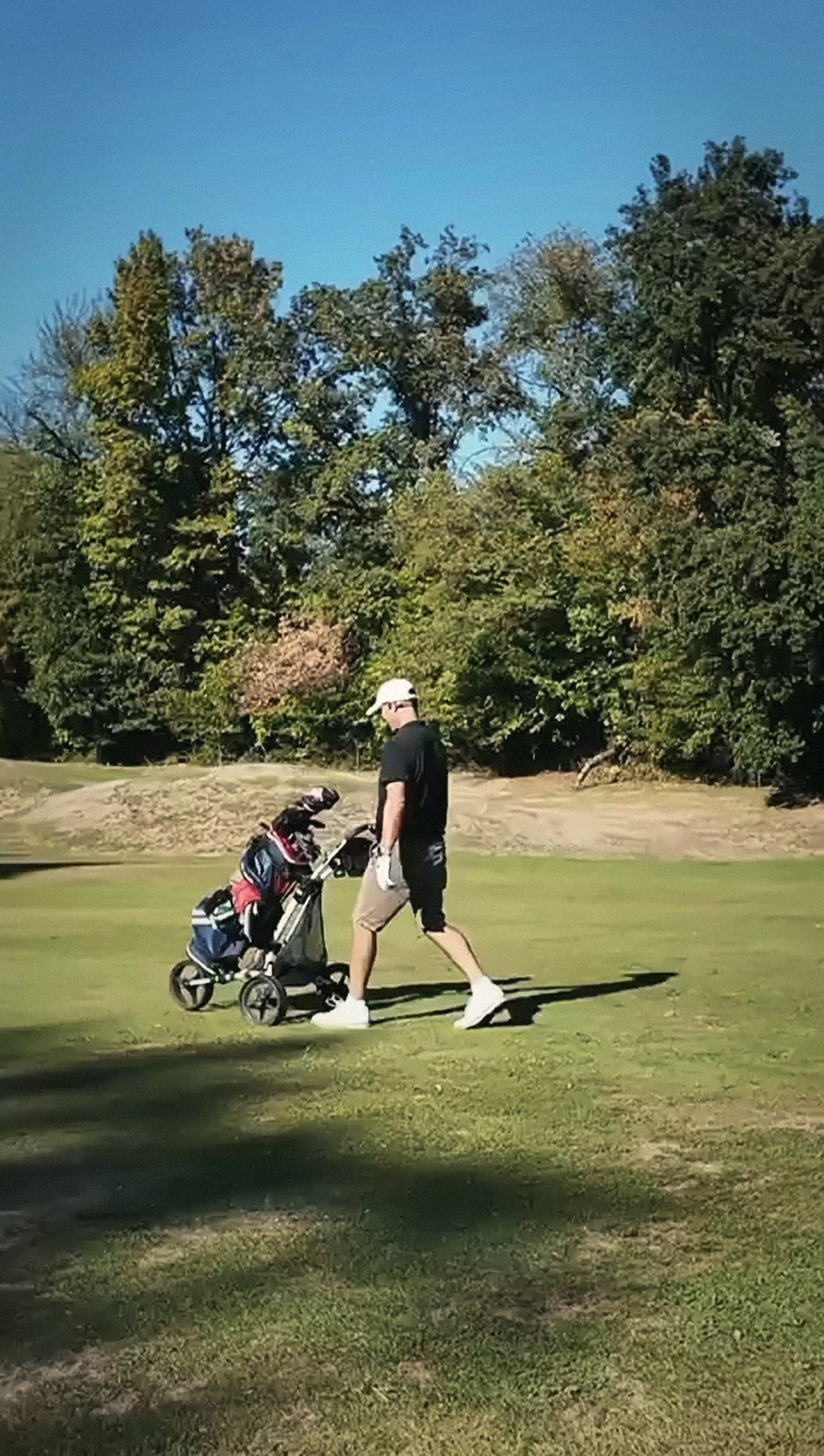 Golfeur et son chariot sur le parcours